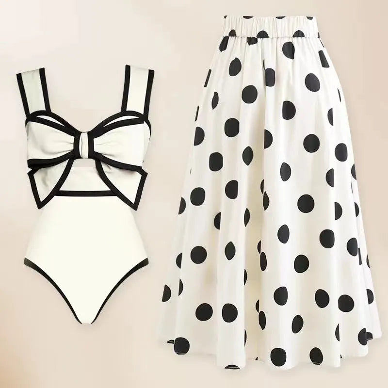 Women's black one-piece swimsuit with a white round skirt and a bow at the centre front