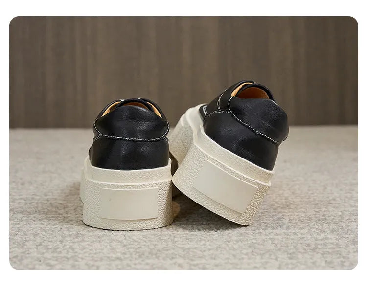 Black and white women's embossed leather platform sports shoes with a round toe and rubber sole.