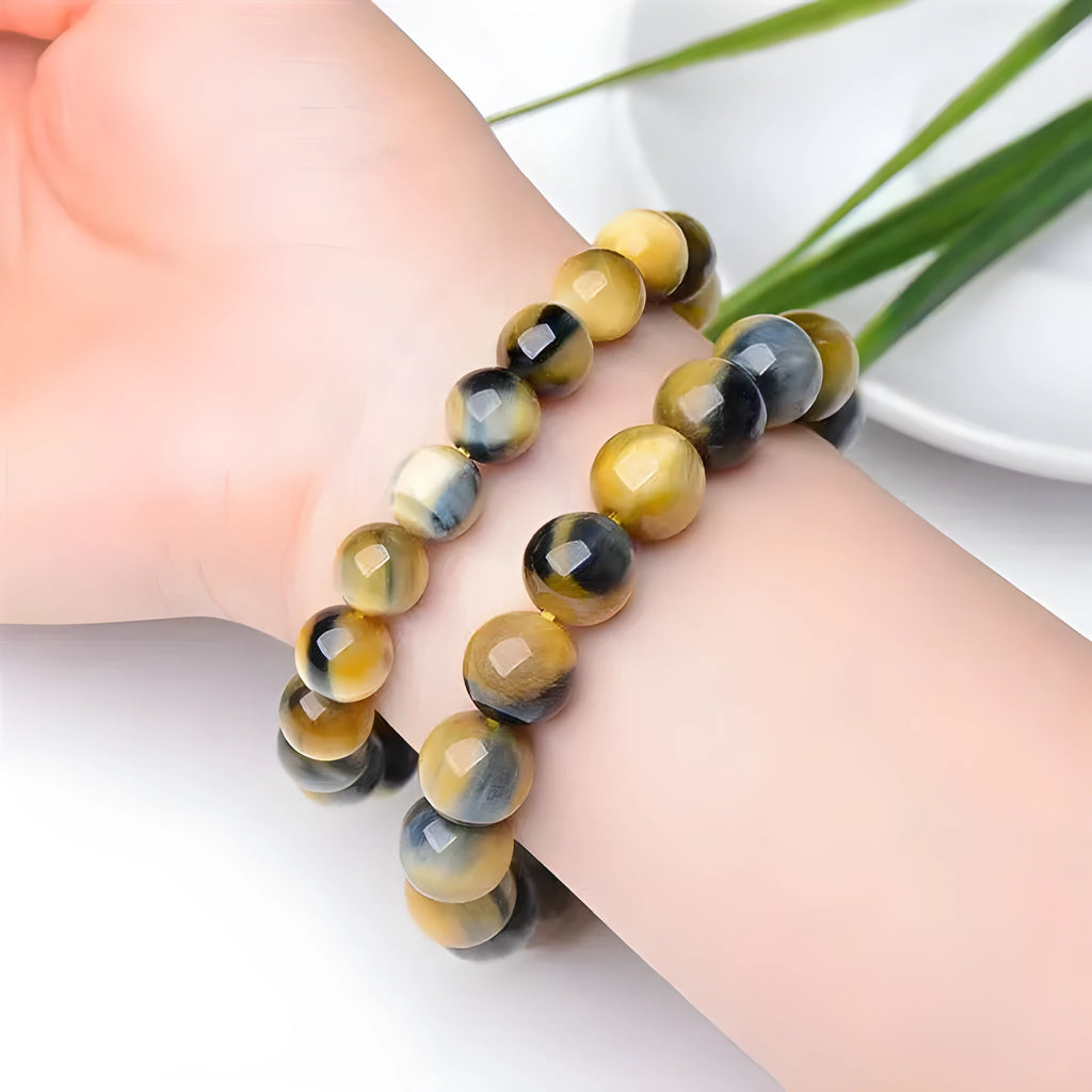 Close-up of a Fantasy Tiger Eye agate bracelet with round geometric beads on a wrist.