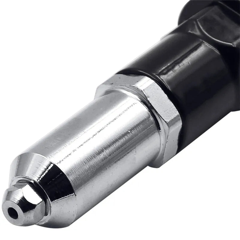Black metal electric drill rivet gun with adapter and four rivet heads on a workbench.