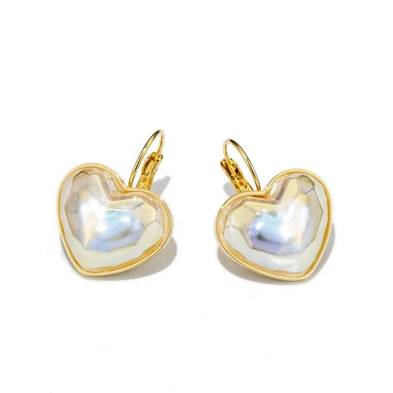 A pair of gold-coloured clip-on earrings with a metallic finish and natural styling.