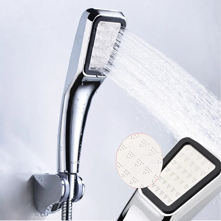 Orange hand-held pressurised shower with hose, set on a bathroom tile background.