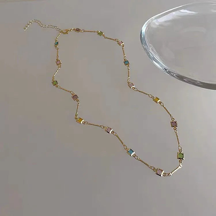 Square geometric artificial crystal pendant on clavicle-length alloy chain necklace in gold tone