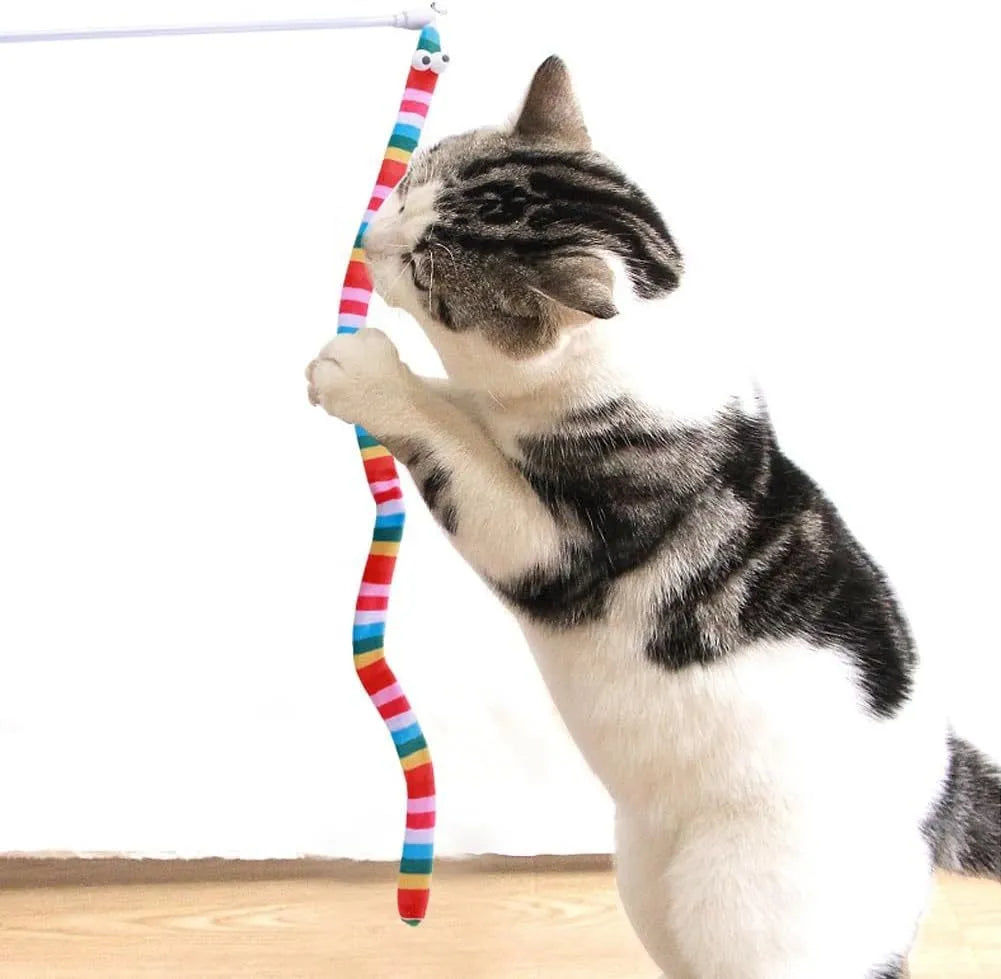 A colourful cat teaser wand with a long plush strip and a bell, held by a person.