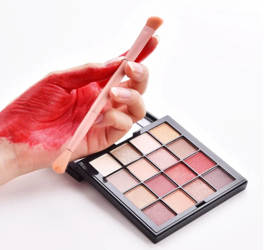 Ten professional makeup brushes with wooden handles in a pink box, including powder, foundation, and double-ended brushes.
