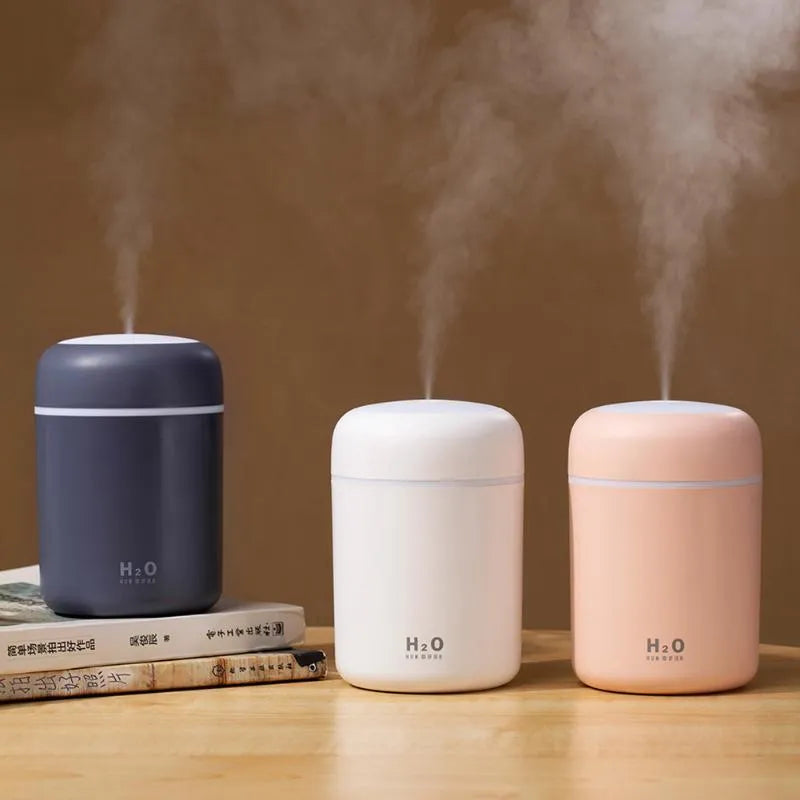 USB mini humidifier with colourful lights in pink, white, or navy blue colours on a desk