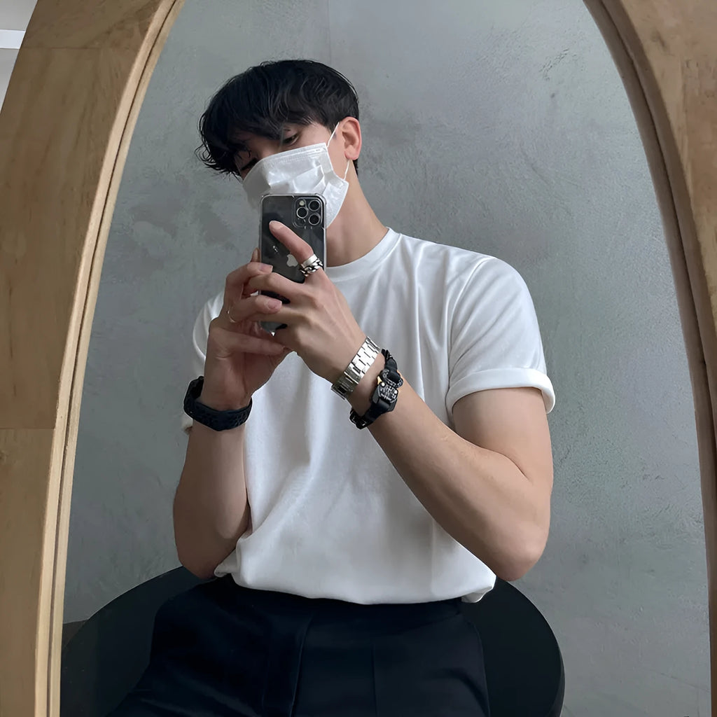 Man wearing a slim fit black cotton t-shirt with a round neck and regular sleeves.