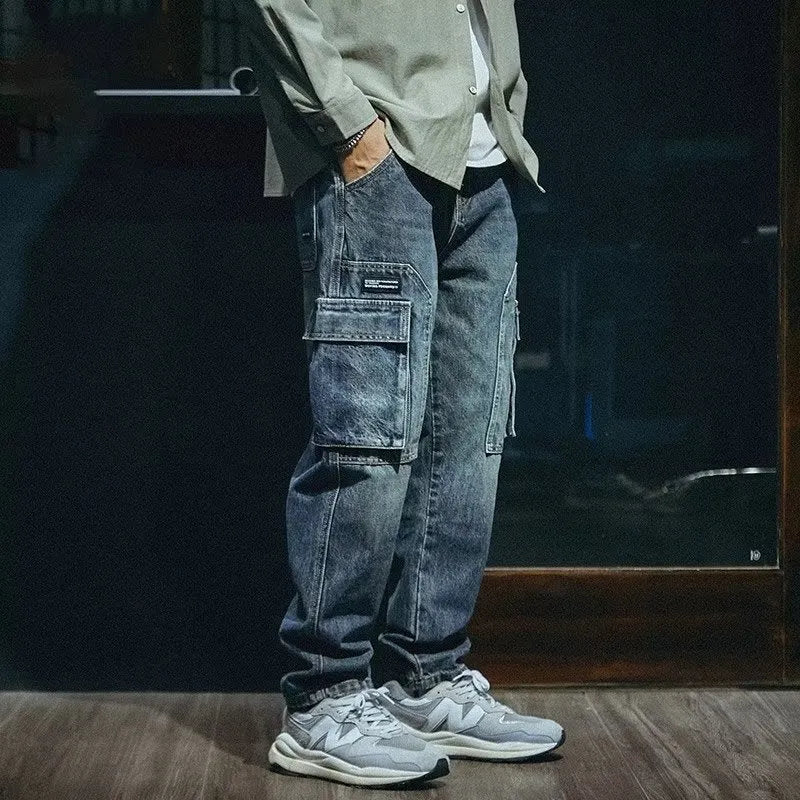 Man wearing blue loose straight-leg denim trousers with a zip fly, showcasing a casual retro style.