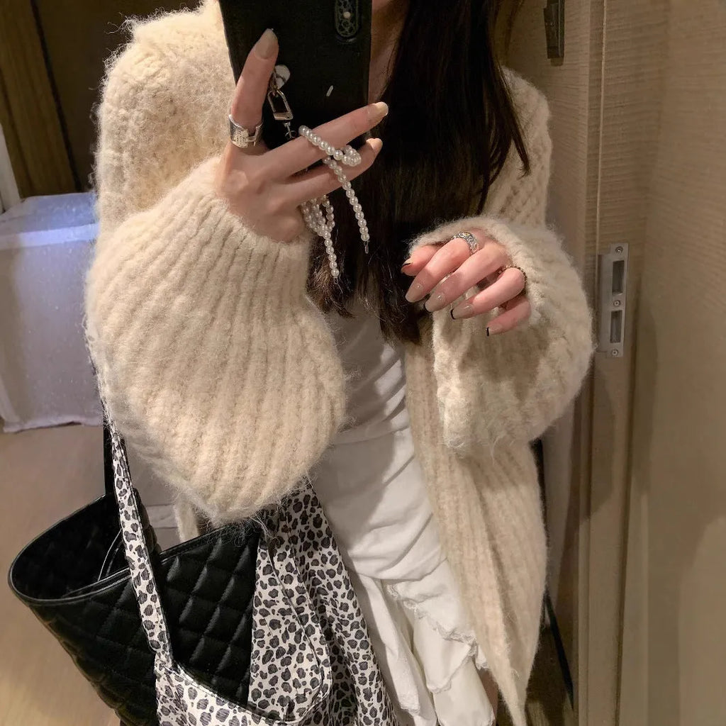Woman wearing a dark gray retro-style hooded cardigan sweater with a loose fit.