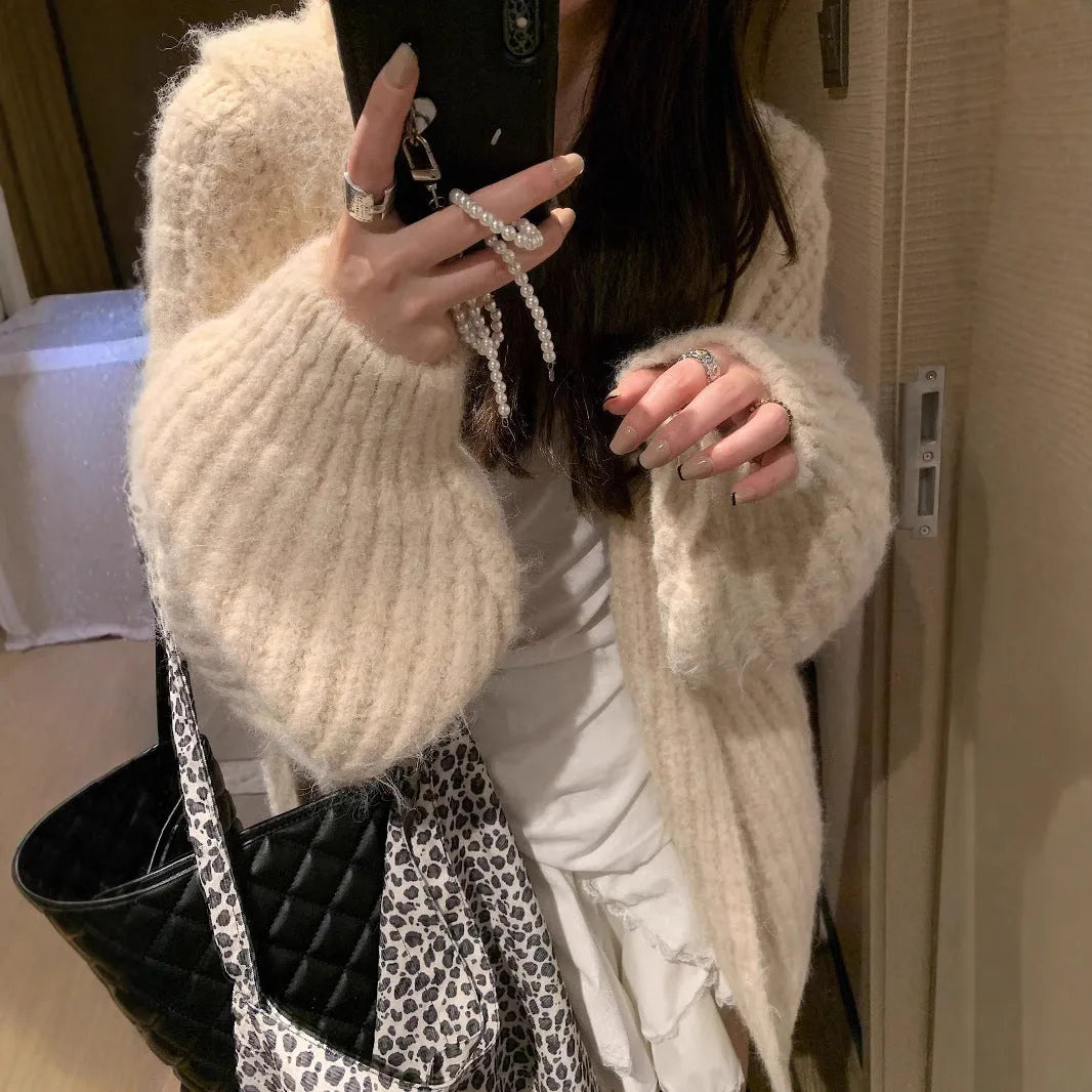 Woman wearing a dark gray retro-style hooded cardigan sweater with a loose fit.