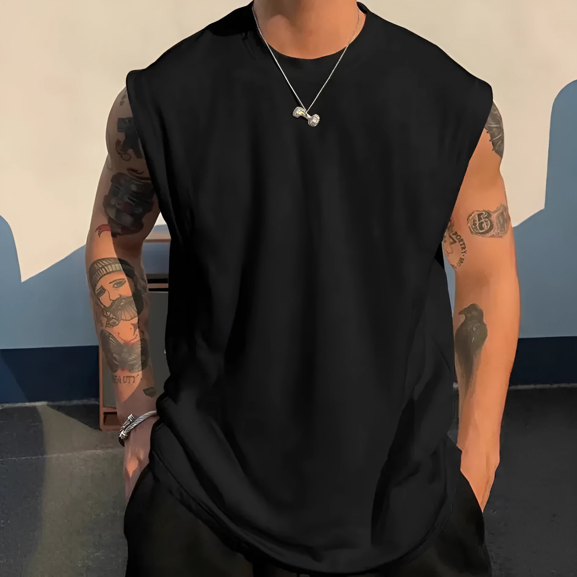 Men's loose fit cotton sleeveless t-shirt in a solid colour, shown on a hanger.