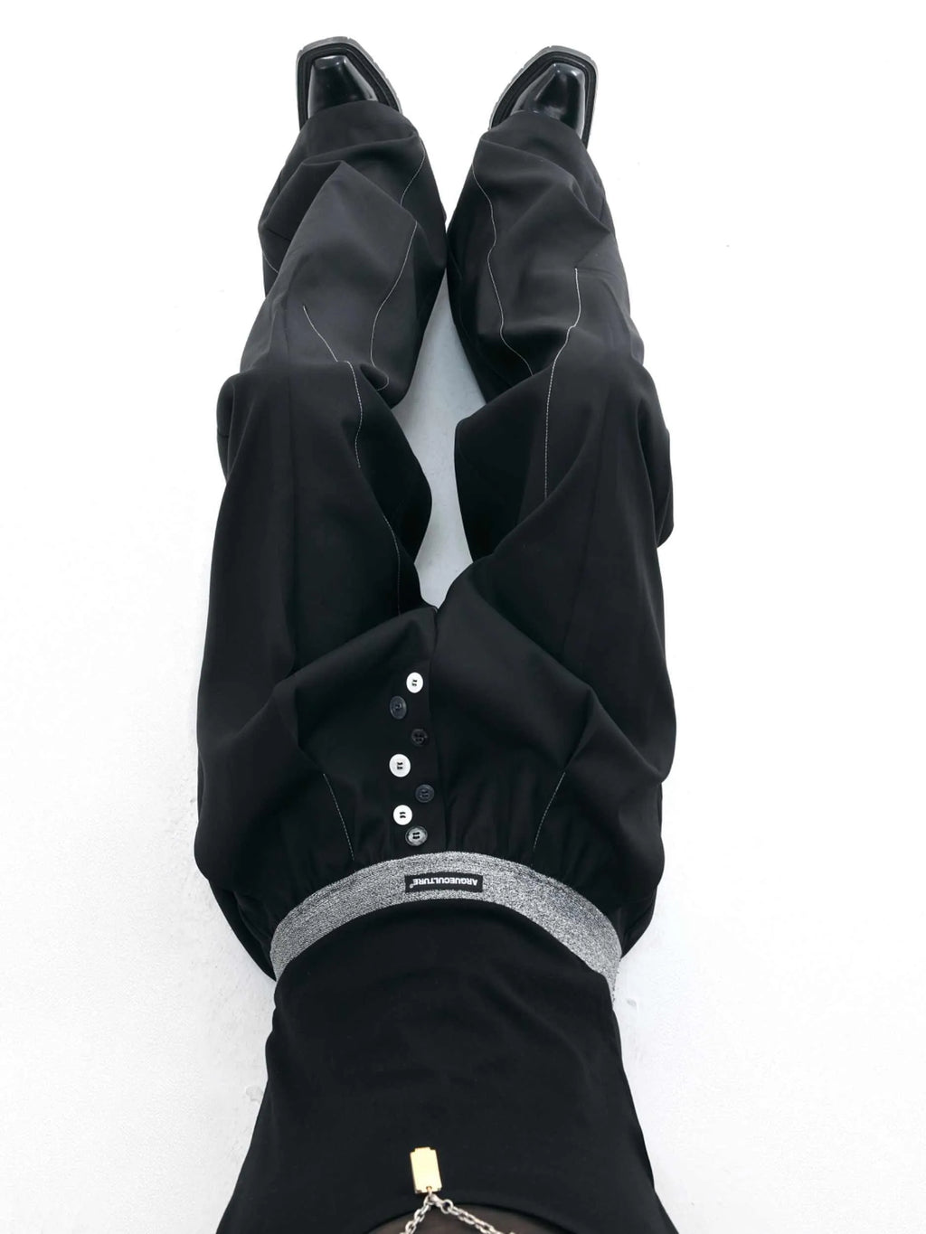 Man's black high-waisted straight-leg casual trousers with a button fly.