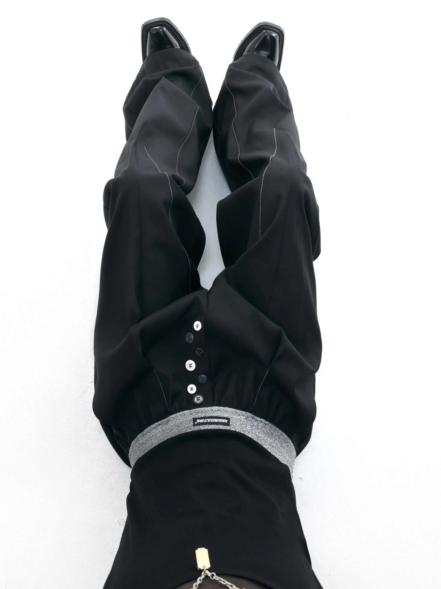 Man's black high-waisted straight-leg casual trousers with a button fly.