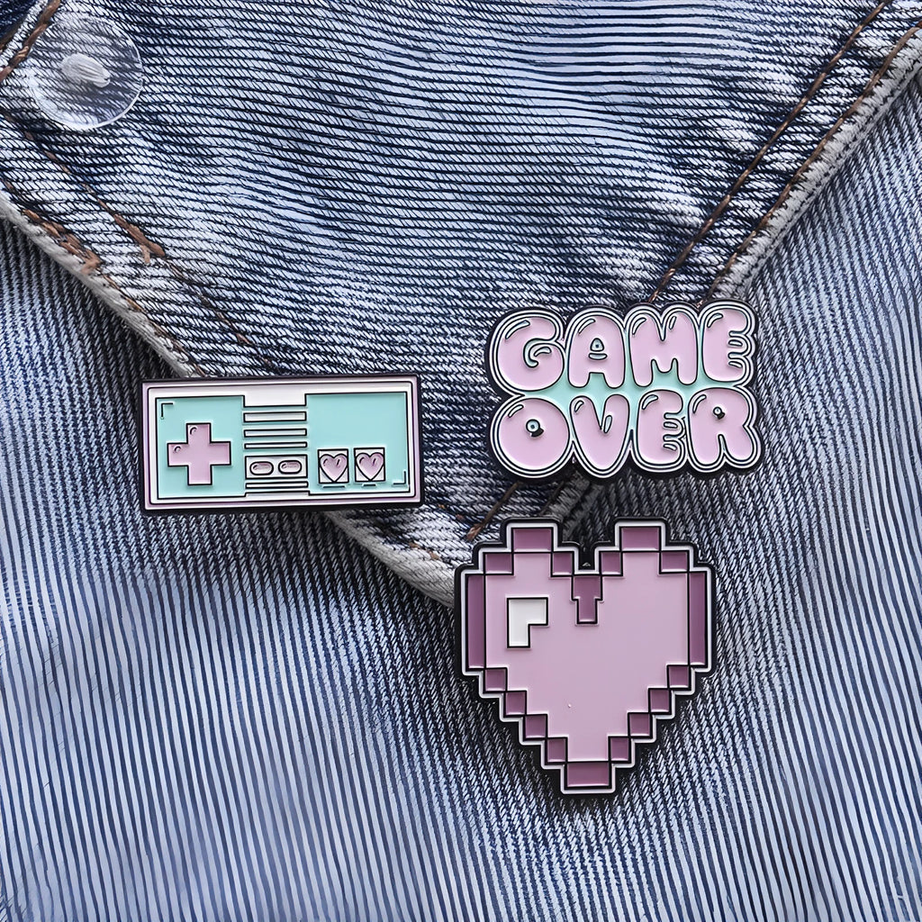 Stereo game console badge pin made from alloy metal on a bag, showing three colour variant options.