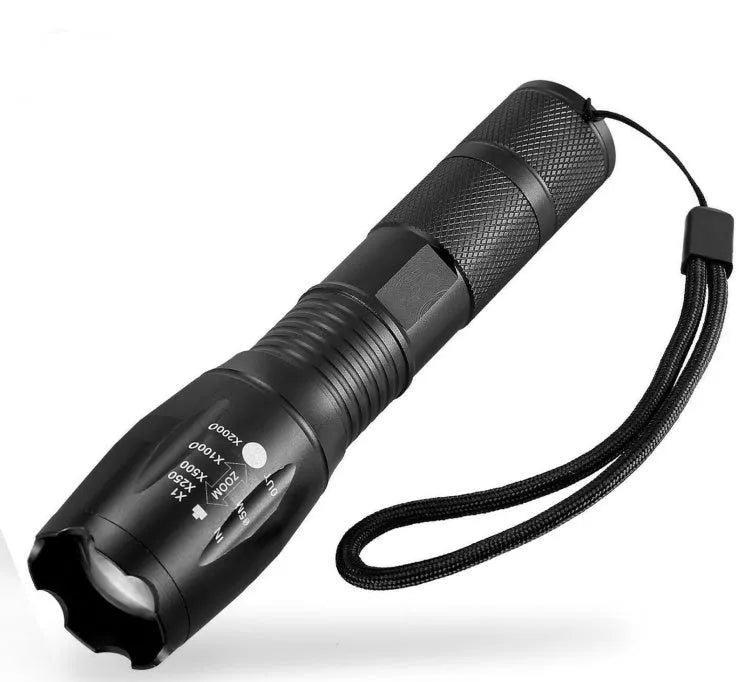 Black aluminium zoom flashlight showing adjustable head for focus, next to an 18650 battery.