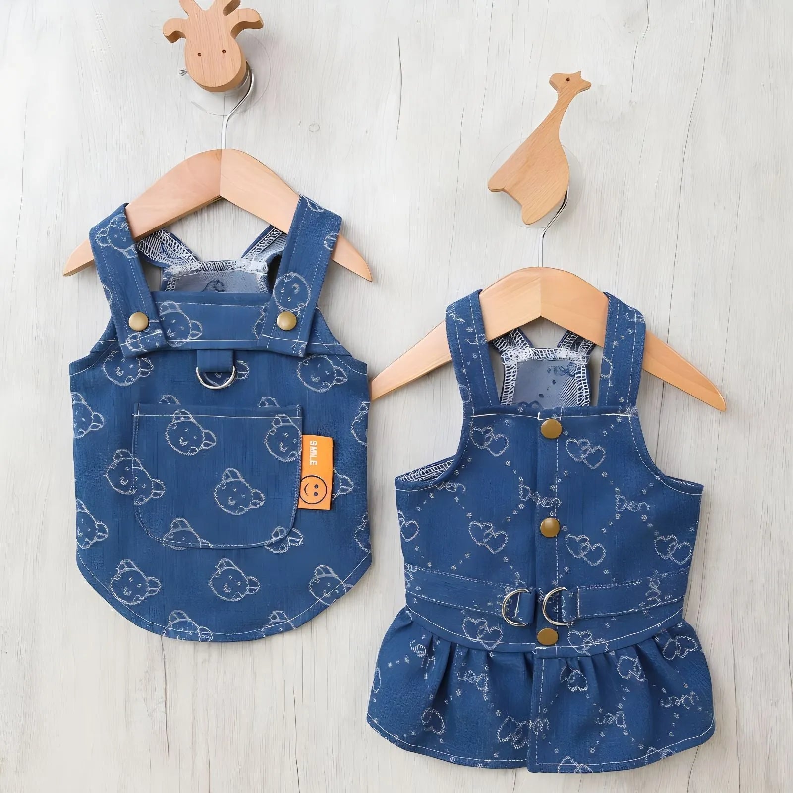 A small white Bichon dog wearing a light blue denim princess dress with a brace skirt design.