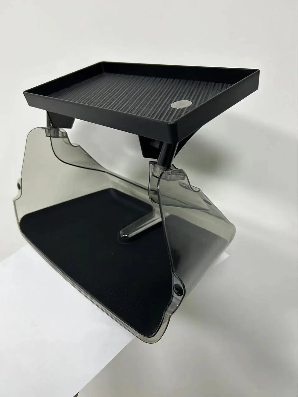 Black ABS plastic storage box installed under the screen of a Tesla Model Y centre console.