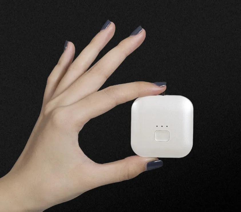 Mini USB air purifier pendant on a necklace, shown in pink colour with charging cable.