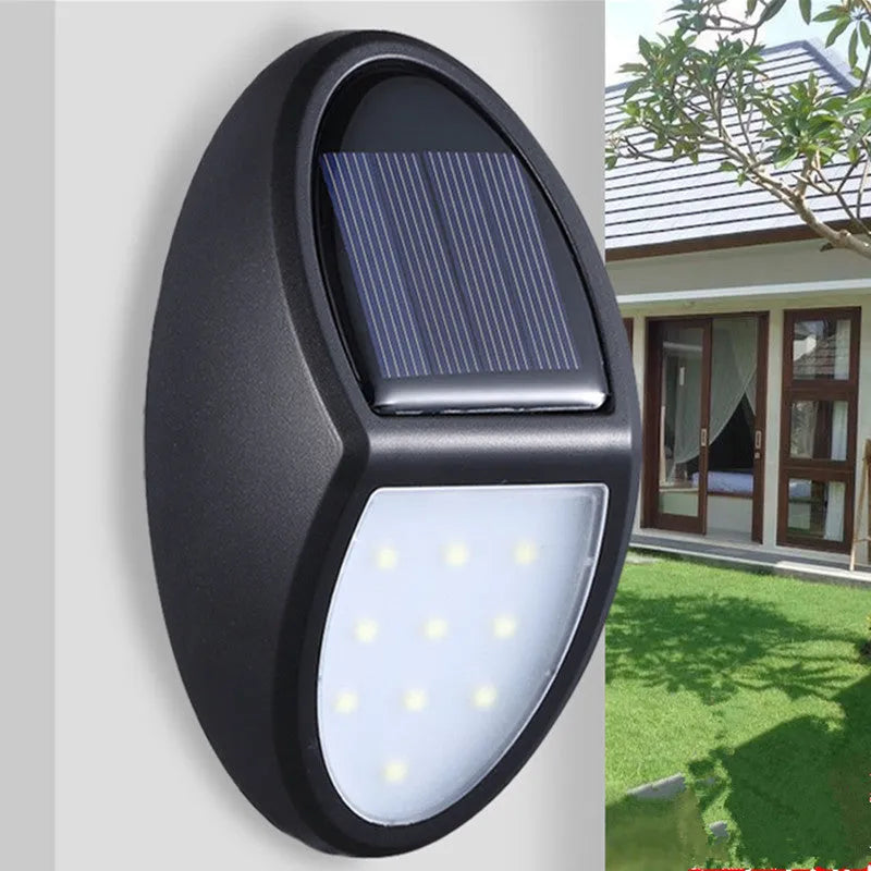Compact black rectangular solar-powered LED wall light mounted on an outdoor wall.
