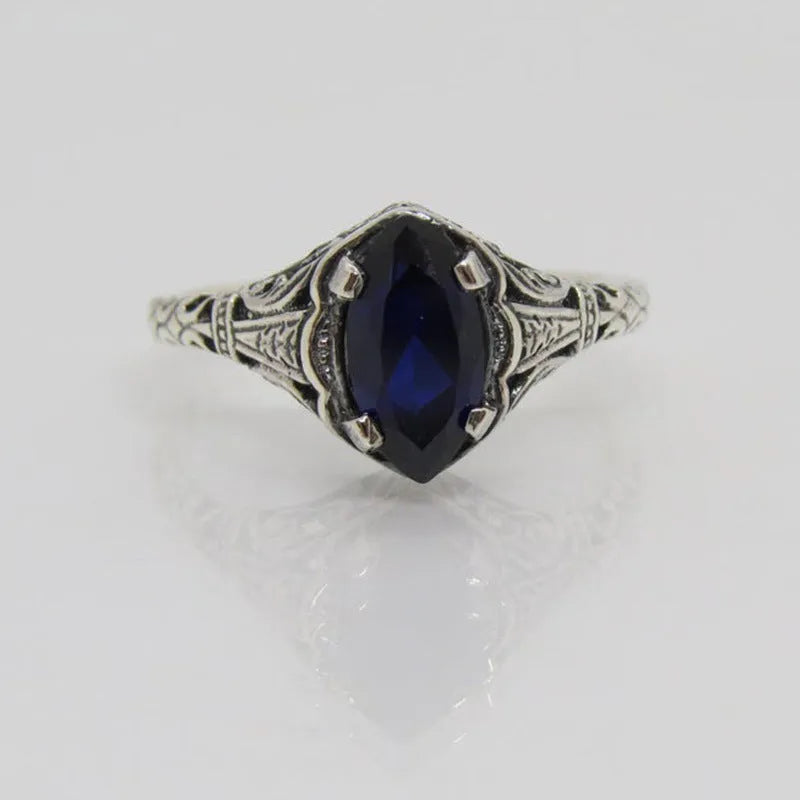 Silver geometric hollow women's ring on grey background showing detailed pattern