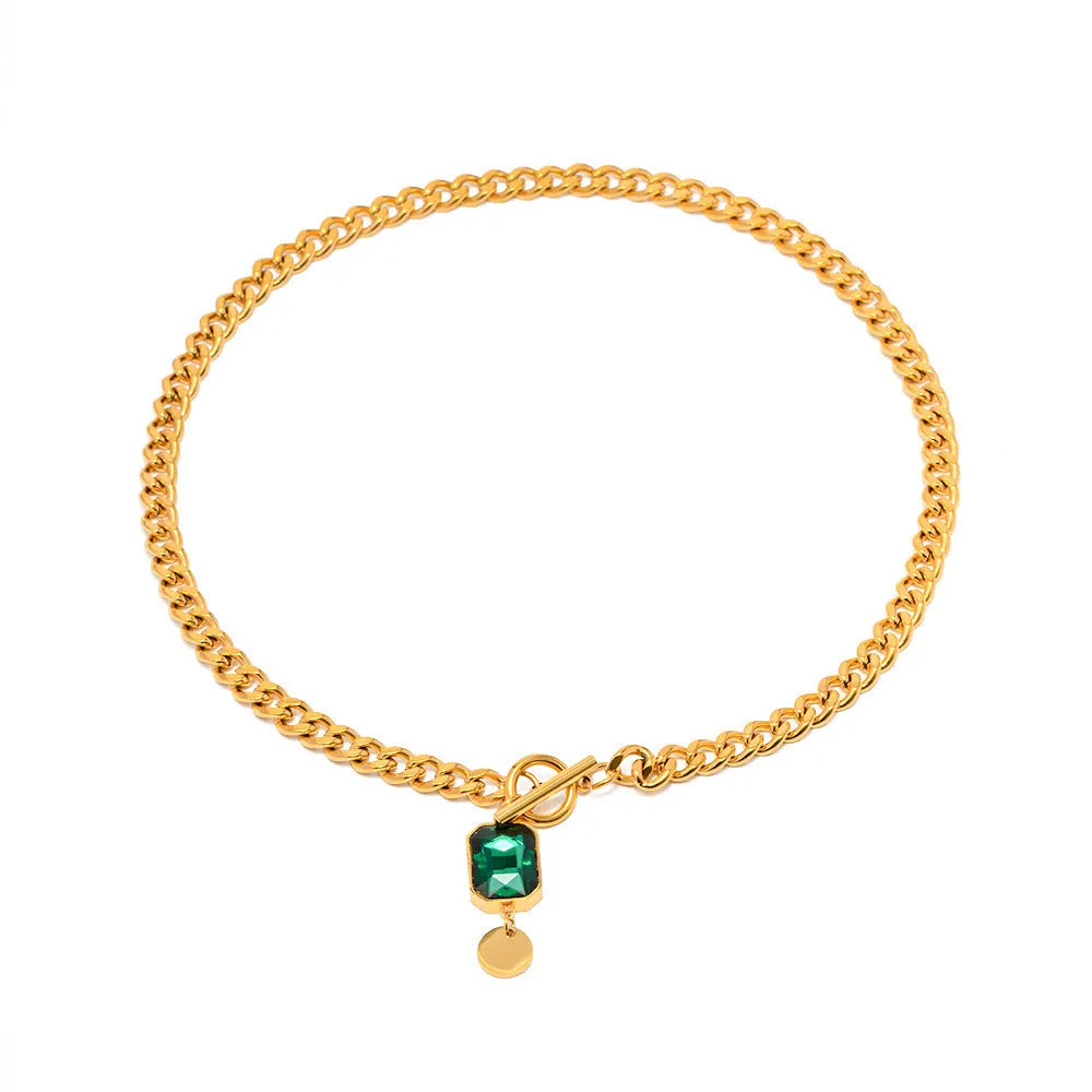 Gold electroplated titanium steel necklace with geometric round pendant containing emerald zircon accents