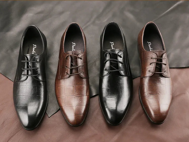 Men's black leather derby shoes with a pointed toe and rubber sole on a neutral background.