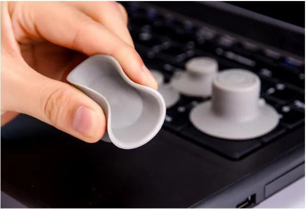 Set of four grey plastic laptop cooling pads, two large and two small, on a flat surface.