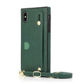 Black leather iPhone case with card holder slot and attached wrist strap on a table.