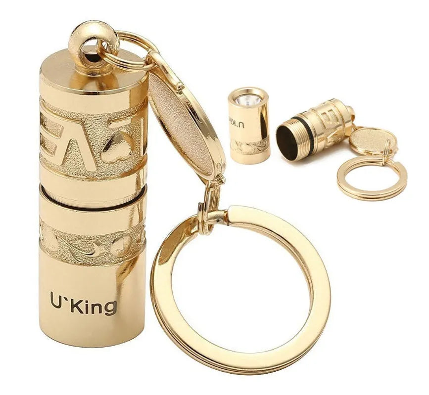 Gold zinc alloy waterproof mini LED flashlight on a keychain.