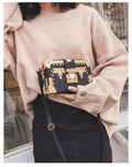 Women's hard frame shoulder bag in black or green with single adjustable strap and flap closure