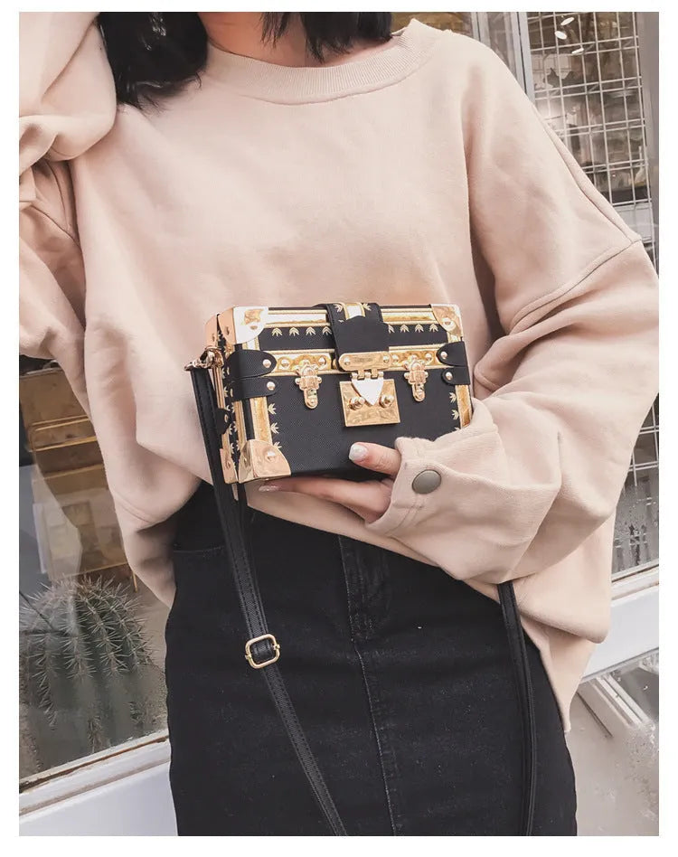 Women's hard frame shoulder bag in black or green with single adjustable strap and flap closure