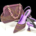 Women's pointed toe high heels with rhinestones and a matching small bag in synthetic leather.