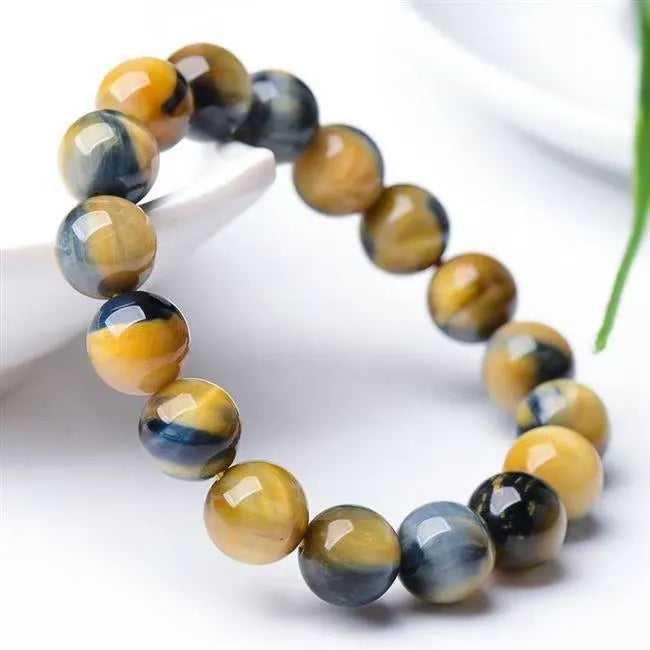 Close-up of a Fantasy Tiger Eye agate bracelet with round geometric beads on a wrist.