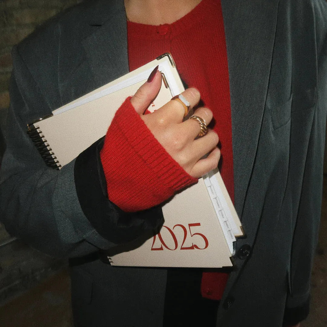 Cherry red coil notebook with spiral binding open to show flat-lying pages for writing