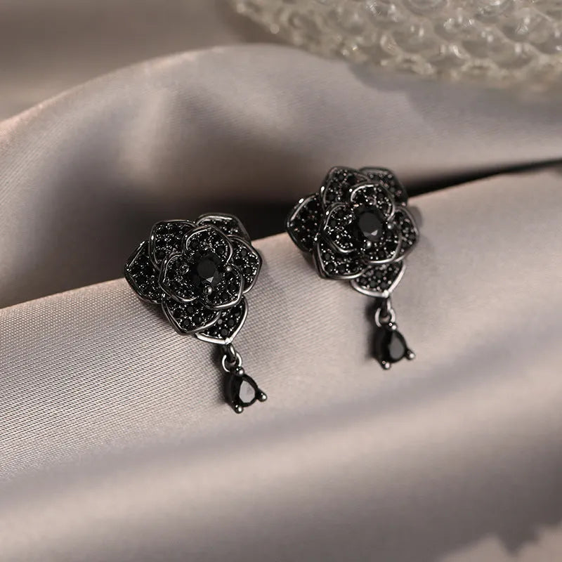 A pair of black rose zircon floral stud earrings with an 18K gold electroplated finish on copper.