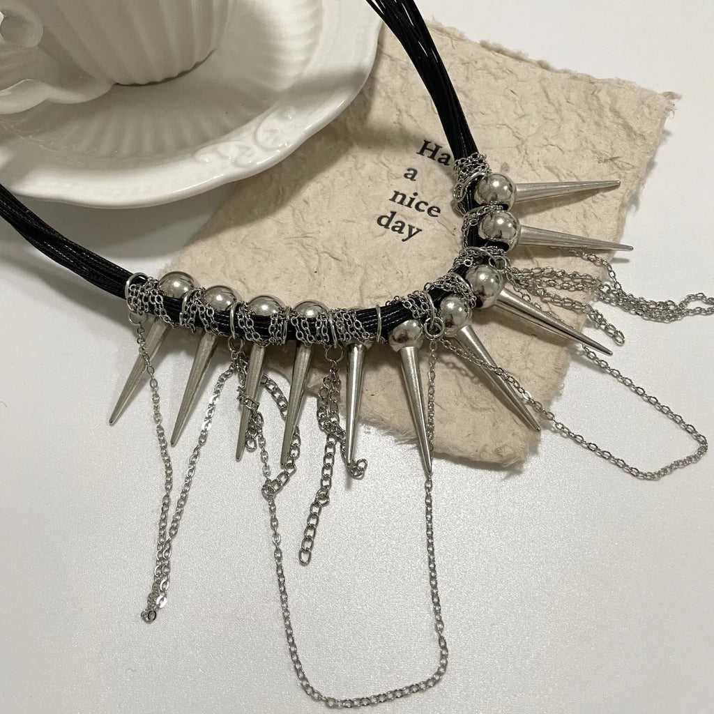 Women's leather necklace with winding beads, a tassel, and metallic point rivets.