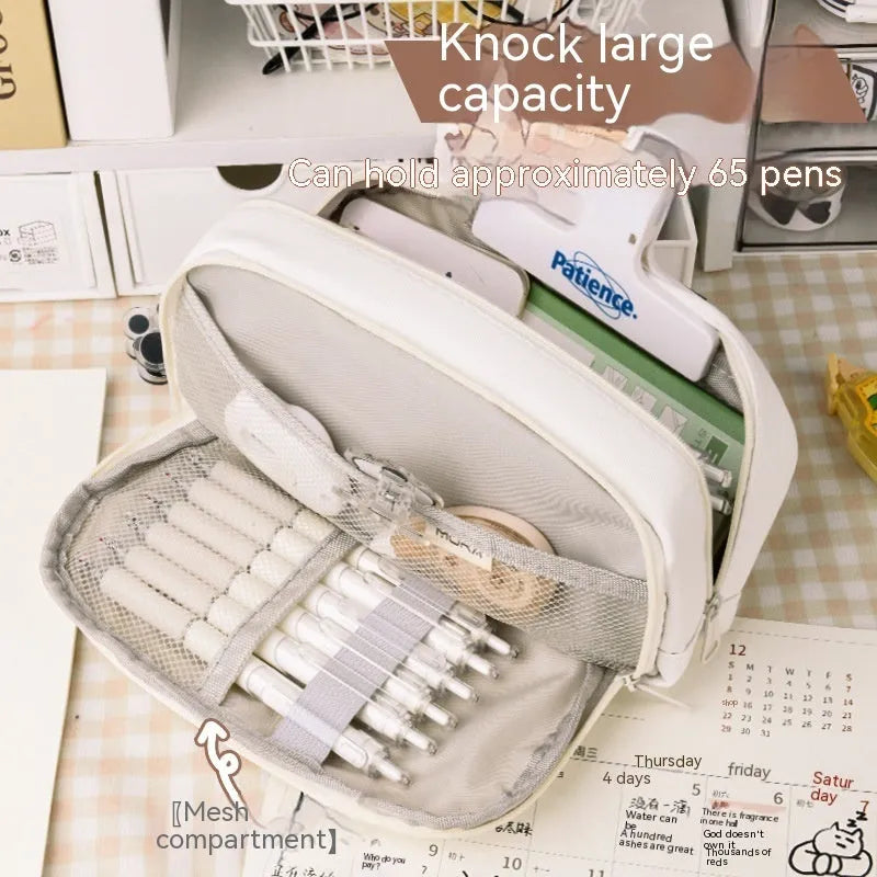 Canvas button-closure pencil case in beige, shown open with pens inside, demonstrating its large capacity.
