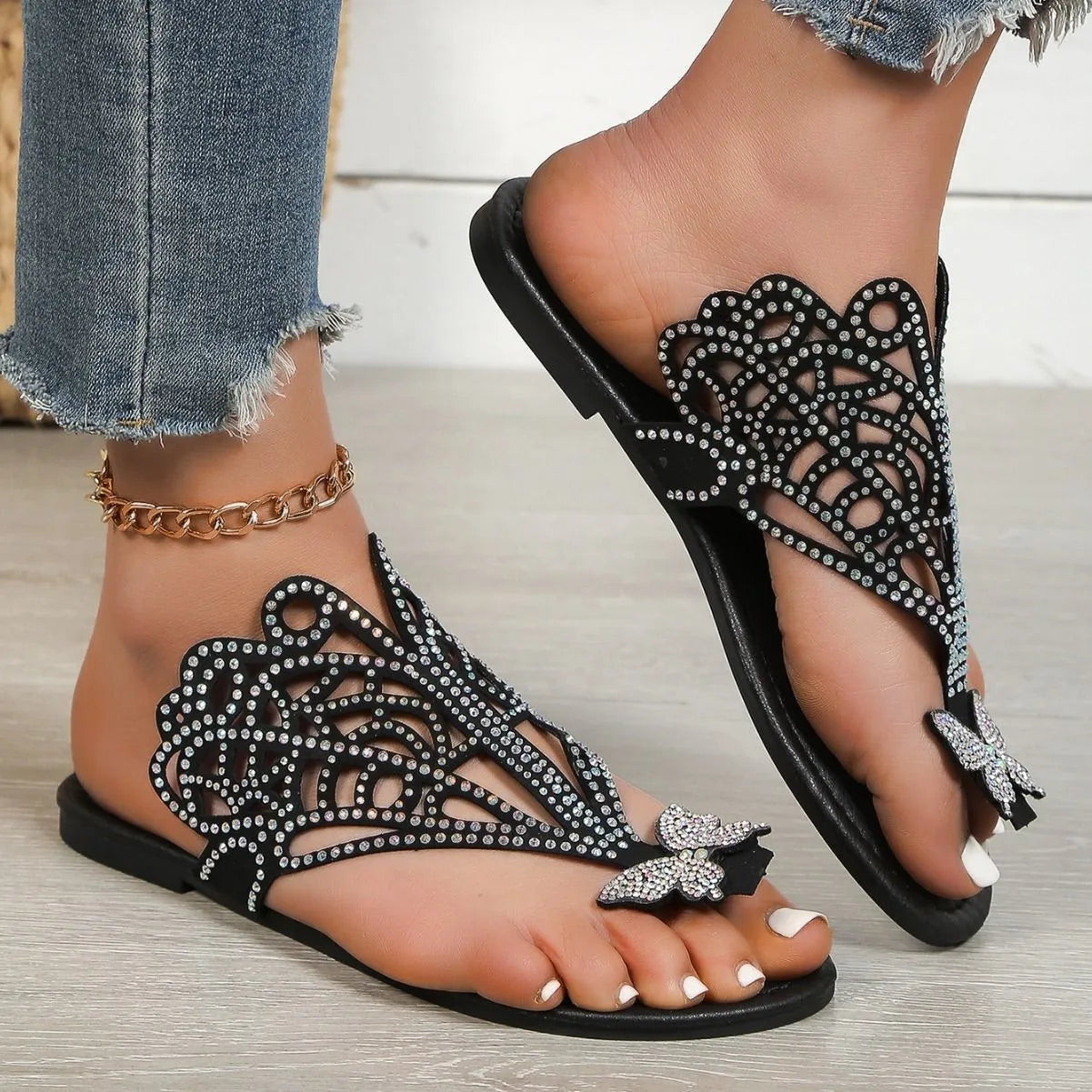 Gold women's flip-toe sandals with hollow-out design and rhinestone decorations on a flat rubber sole.