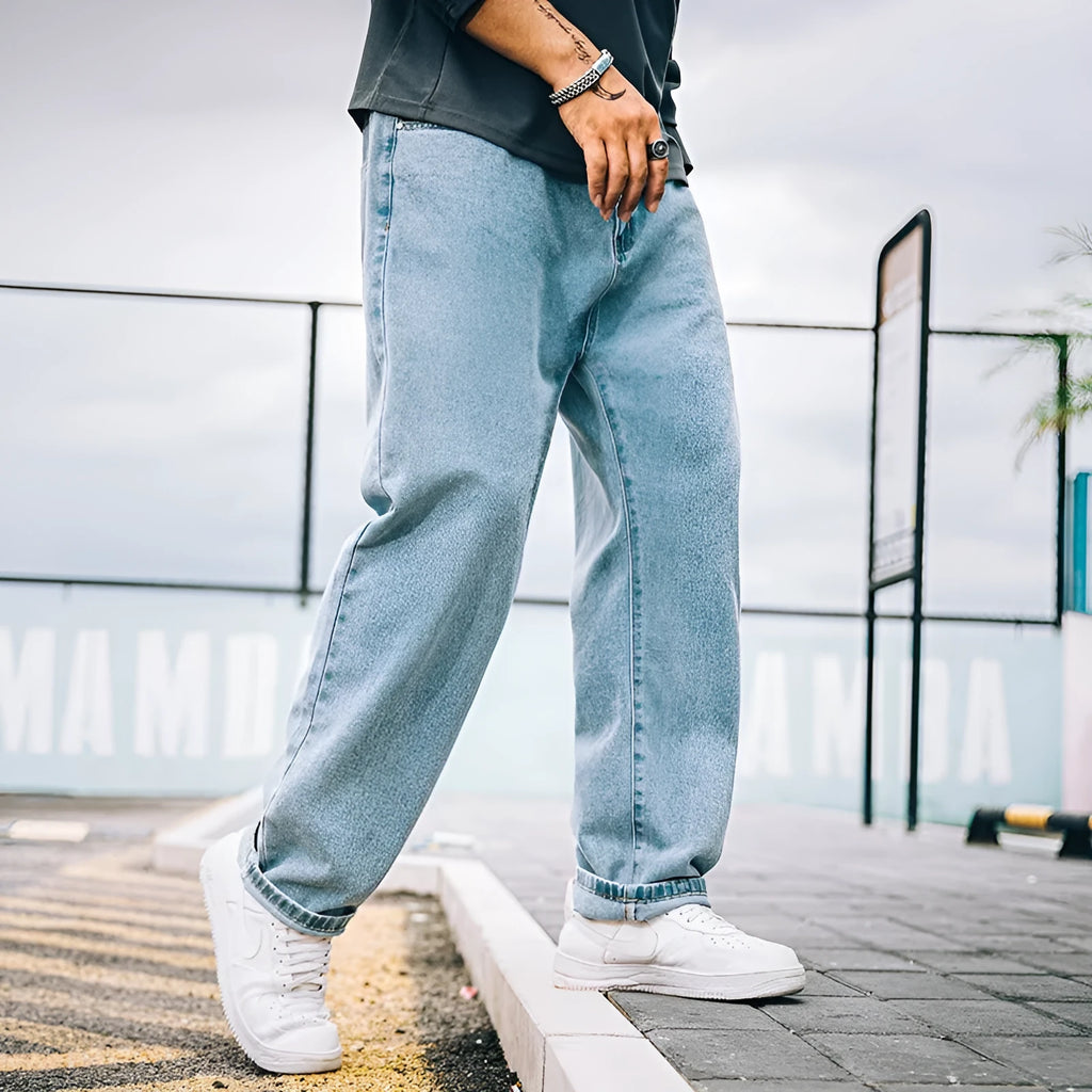 Men's loose straight-leg casual jeans in dark blue cotton on a hanger.