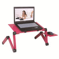 Black folding metal laptop bed desk with cooling fans, shown extended on a bed.