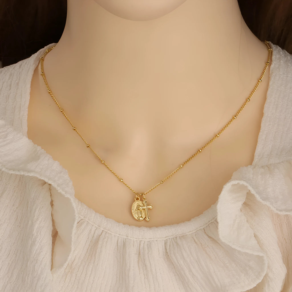 Gold-coloured copper necklace with a geometric cross pendant featuring a Virgin Mary centrepiece.