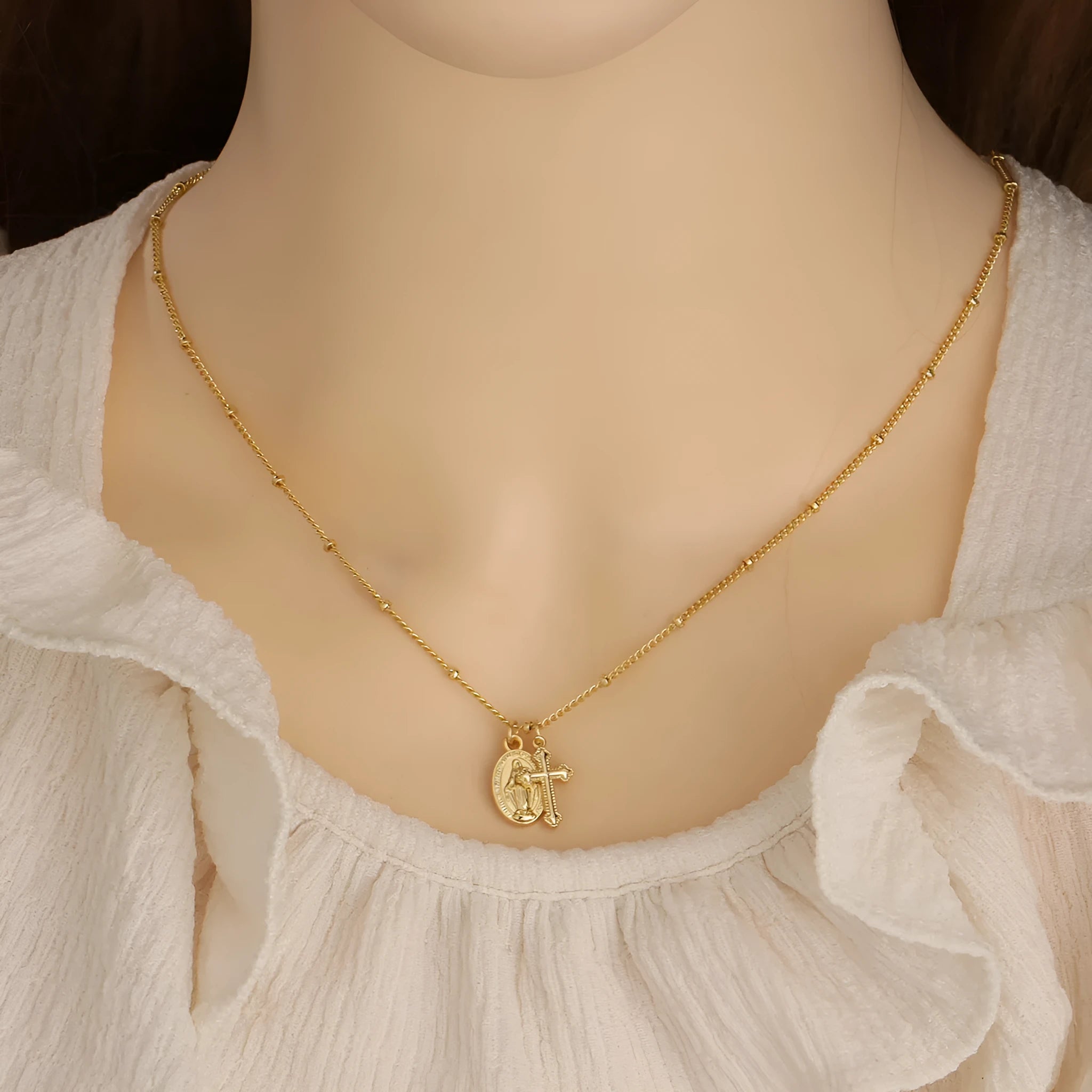 Gold-coloured copper necklace with a geometric cross pendant featuring a Virgin Mary centrepiece.