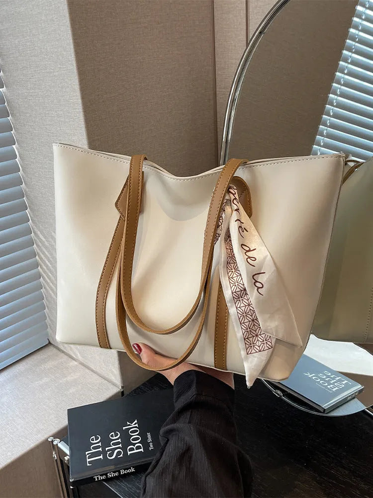 Large soft tote shoulder bag in khaki colour with a crossbody strap and visible sewing line detail.