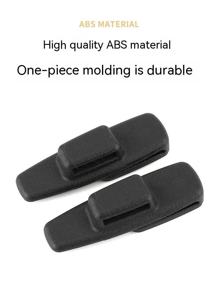 Two black ABS plastic car seatbelt stopper clips on clear OPP packaging.