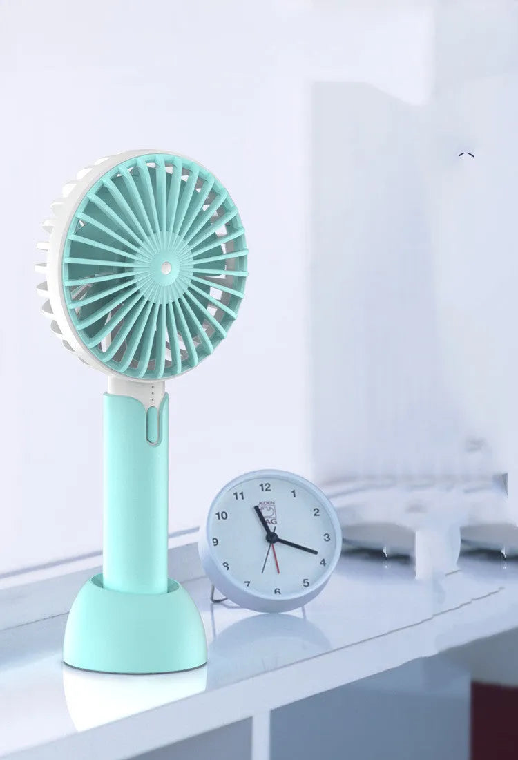 Blue handheld mini USB fan with three speed settings on a desktop