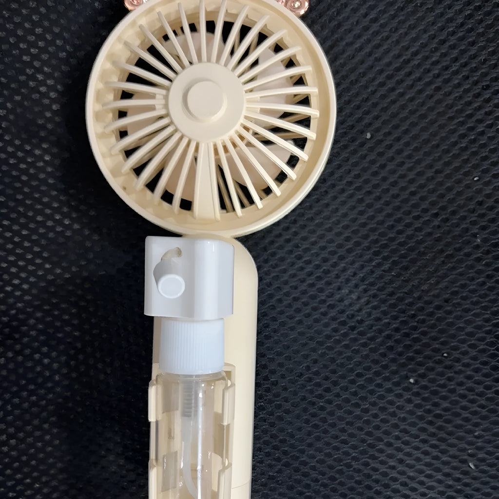 Compact plastic USB desk fan in apricot colour with personalised nozzle, showing scale next to a pen.