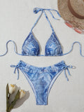 Women's denim blue printed bikini set with halterneck top and side-tie bottoms on a mannequin.