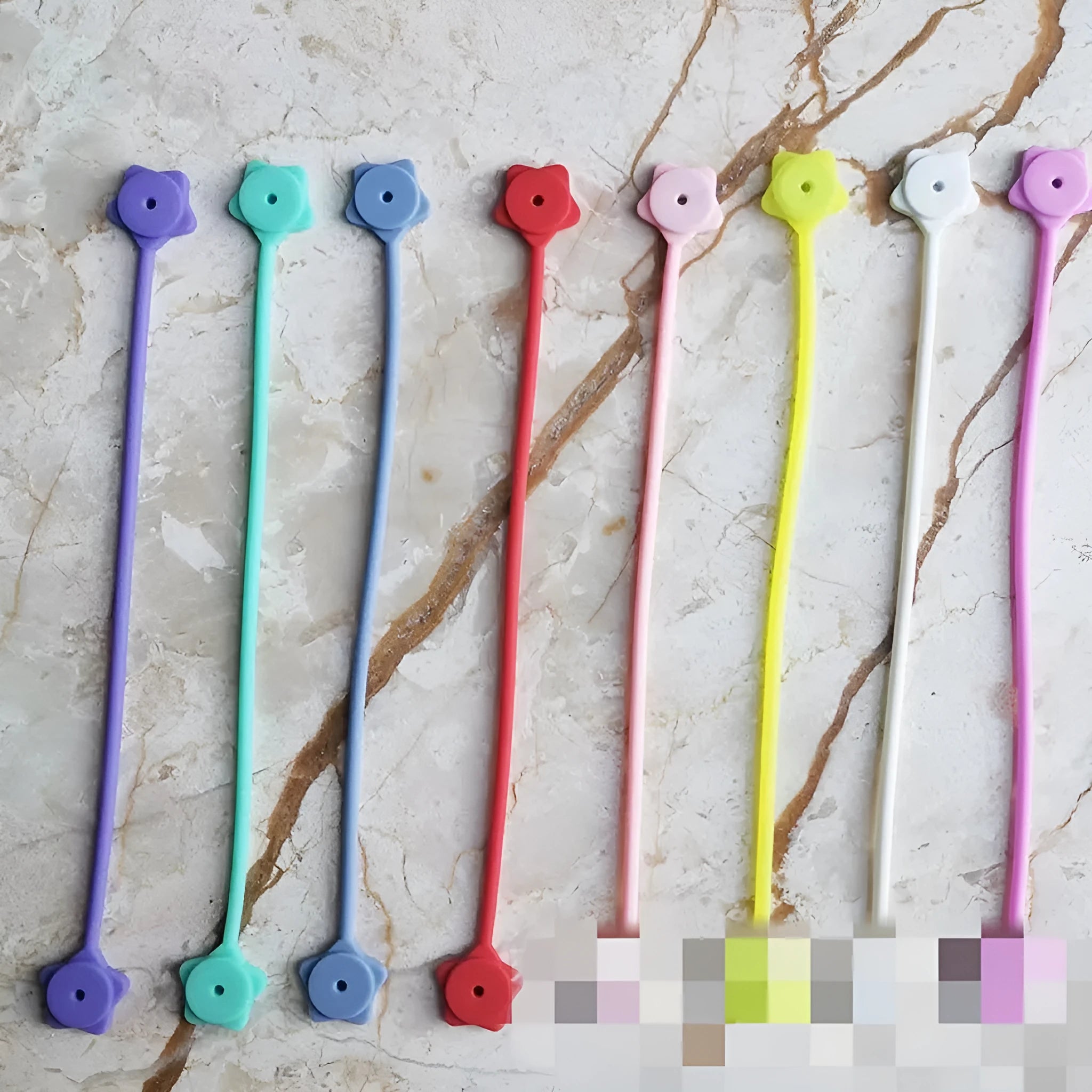 Small purple star-shaped silicone wire winder with magnet clip for organising phone or headphone cables.
