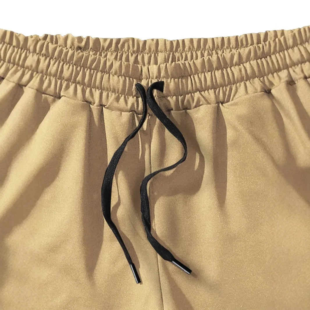 Men's khaki sports shorts with a coconut leaf print, showing straight-leg cut.