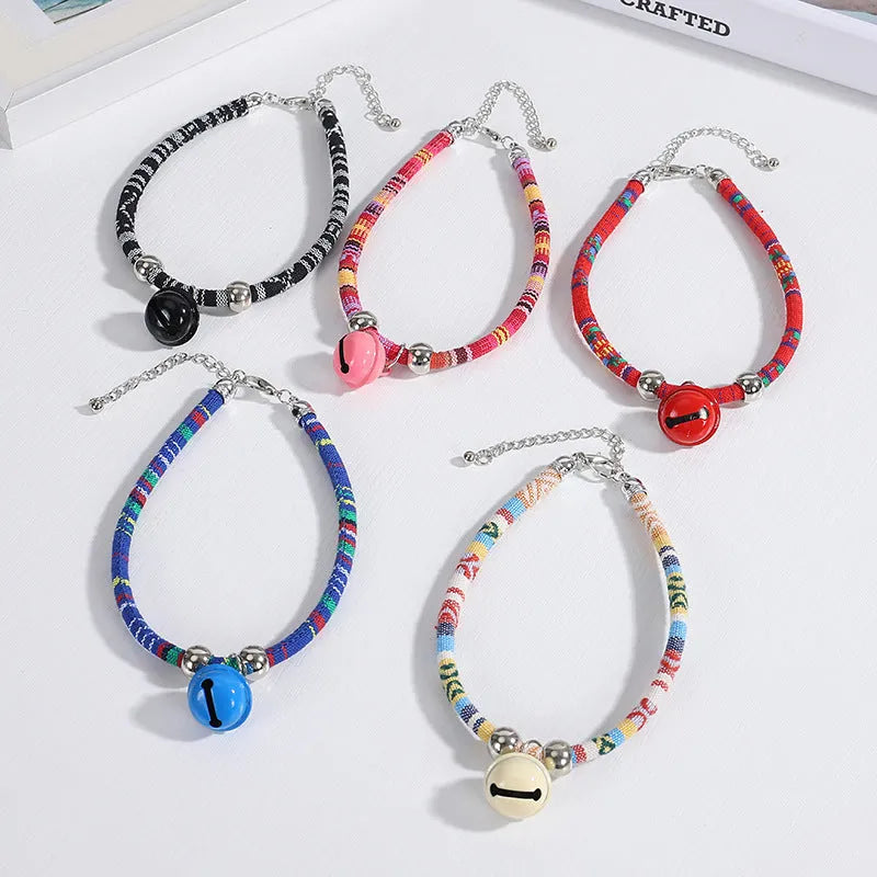 Coloured ethnic-style adjustable pet collar for dogs and cats with a small bell, shown in multiple colour options.